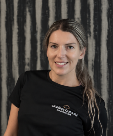 Smiling woman in black Chalets Coburg Boutique Spa shirt