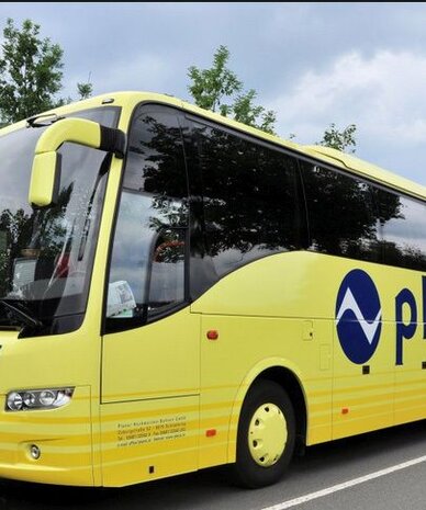 Yellow Planai coach bus parked on the road