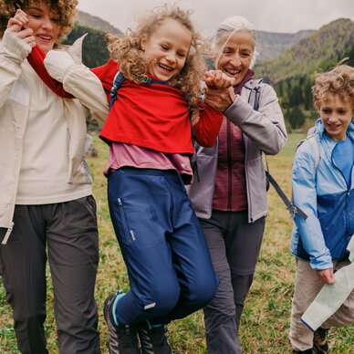 Family of four hiking together in a mountain meadow