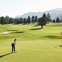 Two golfers on a lush, expansive golf course