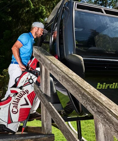 Man loading Callaway golf bag into gondola car