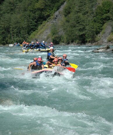 Rafting group wearing helmets on a turbulent river