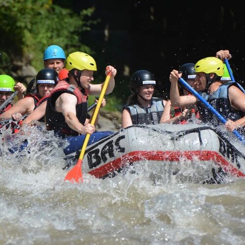 Group of people white-water rafting in an inflatable raft