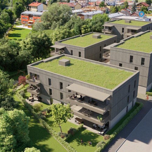 Aerial view of modern apartment buildings with green roofs and surrounding trees