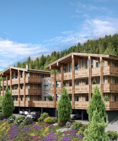 Dreigeschossige Holzhäuser auf einem Hang mit Parkplätzen