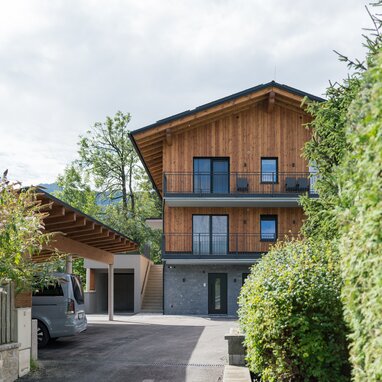 Wooden residential building with balconies and greenery