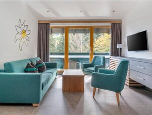 Teal sofa and chairs in bright living room with balcony | © Sarah Kurre