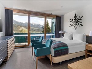 Hotel room with balcony, mountain view, teal chairs | © Sarah Kurre