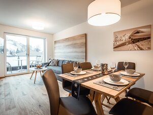 Offener Wohn- und Essbereich mit verschneitem Balkonblick