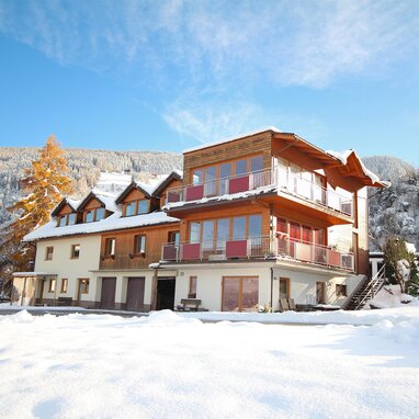 Schneebedecktes Chalet im Alpenstil mit Balkonen