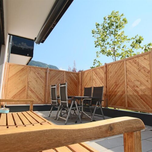 Sunny balcony with wooden privacy fence and seating