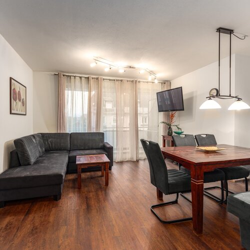 Modern living room with grey sofas and wooden dining table