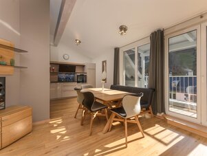 Open-plan kitchen and dining area with wooden table and chairs