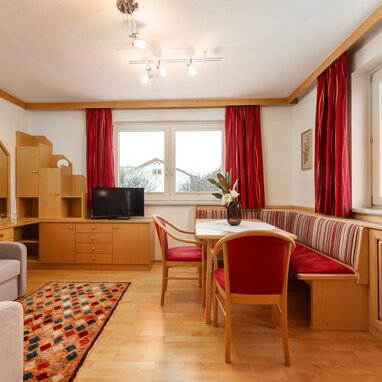 Cozy living room with wooden furniture and red curtains