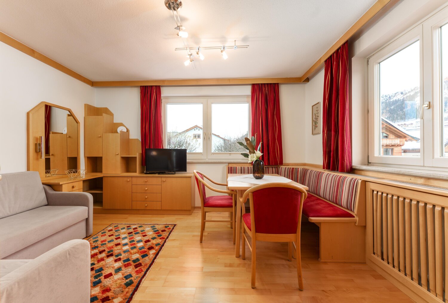 Cozy living room with wooden furniture and red curtains