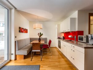 Open-plan kitchen and dining area with red backsplash