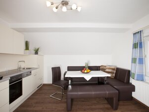 Open-plan kitchen and dining area with brown leather seating