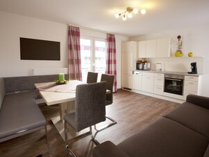 Open-plan living area with dining table and kitchenette
