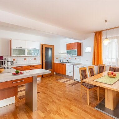 Bright modern kitchen with wooden cabinets and dining table.