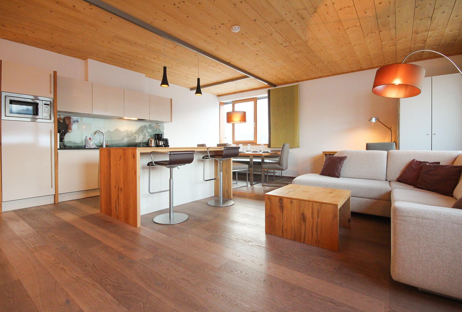 Offener Wohnbereich mit Kücheninsel und Sofa | © SCHLADMING-APPARTEMENTS