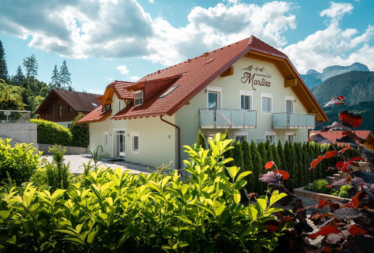 Apartment house Martina with red roof in alpine setting