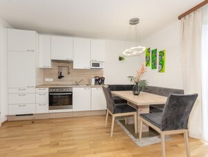 Bright modern kitchen with white cabinets and dining table