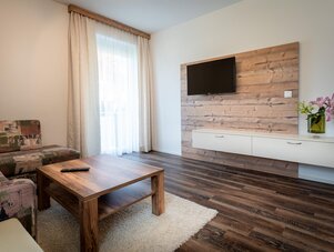 Living room with wooden feature wall and mounted TV