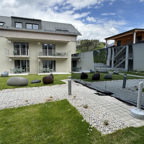 Moderner Innenhof mit Glaskubus-Pavillon und Sitzgelegenheiten