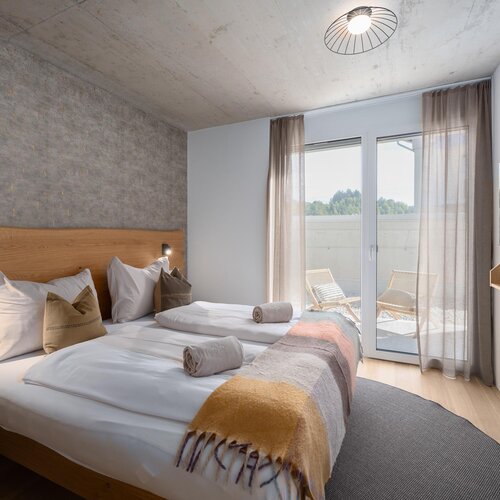 Hotelzimmer mit zwei Betten und Balkonzugang