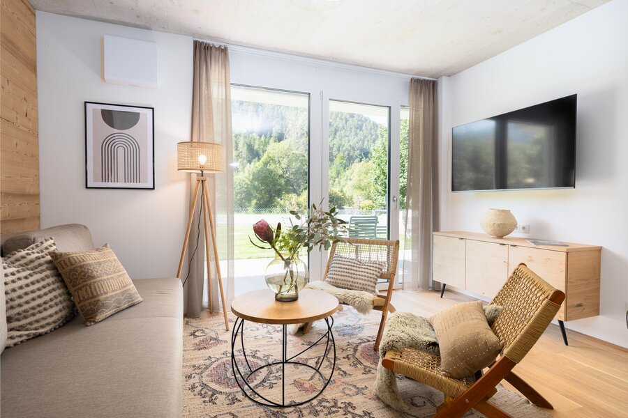 Helles Wohnzimmer mit großen Fenstern und Blick ins Grüne