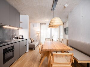 Open-plan kitchen and dining area with wooden table and sofa