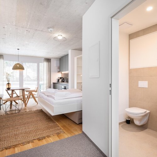 Helles Studio-Suite mit Bett, Essbereich und Badezimmer.