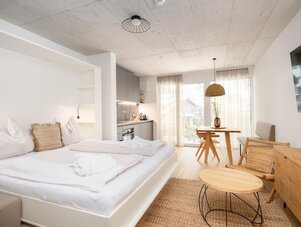 Bright modern studio with bed, kitchenette, and dining area