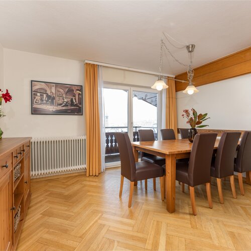Bright dining room with wooden table and brown chairs
