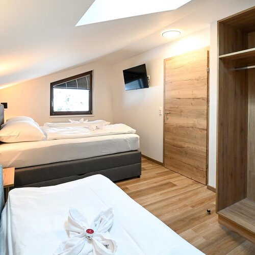 Hotelzimmer mit zwei Betten, Kleiderschrank und Fernseher