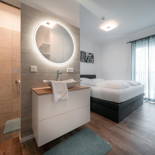 Modern hotel room with open bathroom and bed