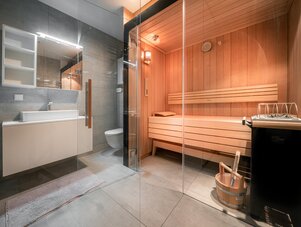 Contemporary bathroom with glass partition and wooden sauna