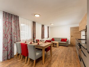 Offener Wohn- und Essbereich mit roten Akzenten.