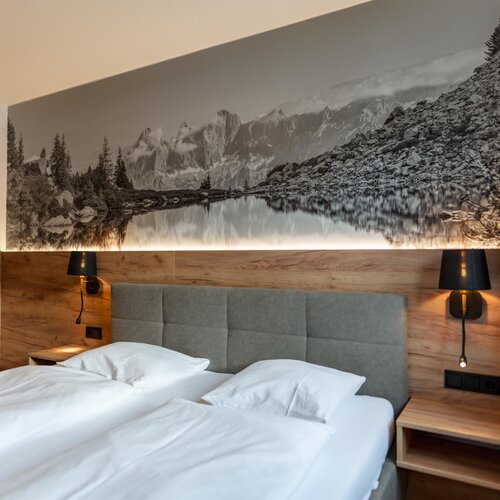 Hotel bedroom with large mountain mural above the bed