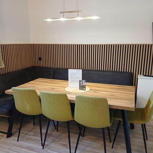 Moderner Essbereich mit Holztisch, Eckbank und grünen Stühlen