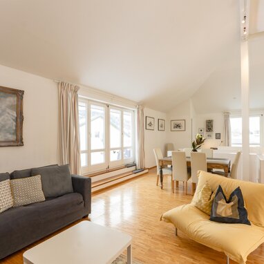 Bright open living and dining area with large windows