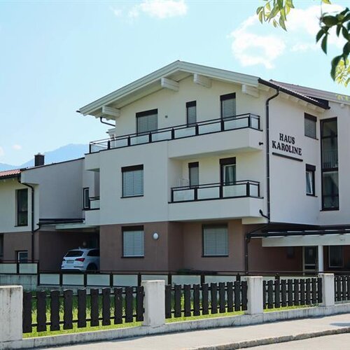 Modern white apartment building with balconies, sign Haus Karoline