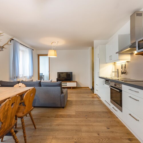 Offener Wohn- und Essbereich mit Sofa und Küche.