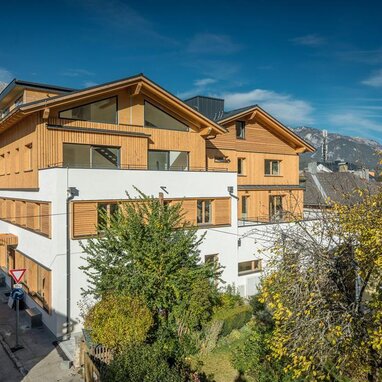 Modernes Mehrfamilienhaus mit Holzverkleidung an der Straße