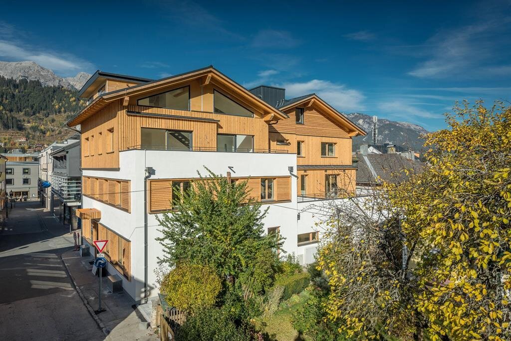 Modernes Mehrfamilienhaus mit Holzverkleidung an der Straße