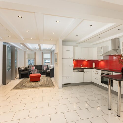 Bright open plan kitchen and living room with red backsplash