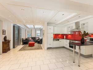 Bright open-plan kitchen and living area with red backsplash