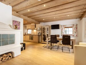 Open-plan living area with kitchen, dining table, and fireplace