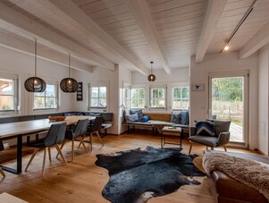 Heller offener Wohnraum mit Esstisch und Bänken