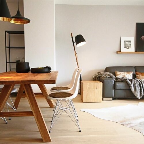 Heller offener Wohn- und Essbereich mit Holztisch und Sofa